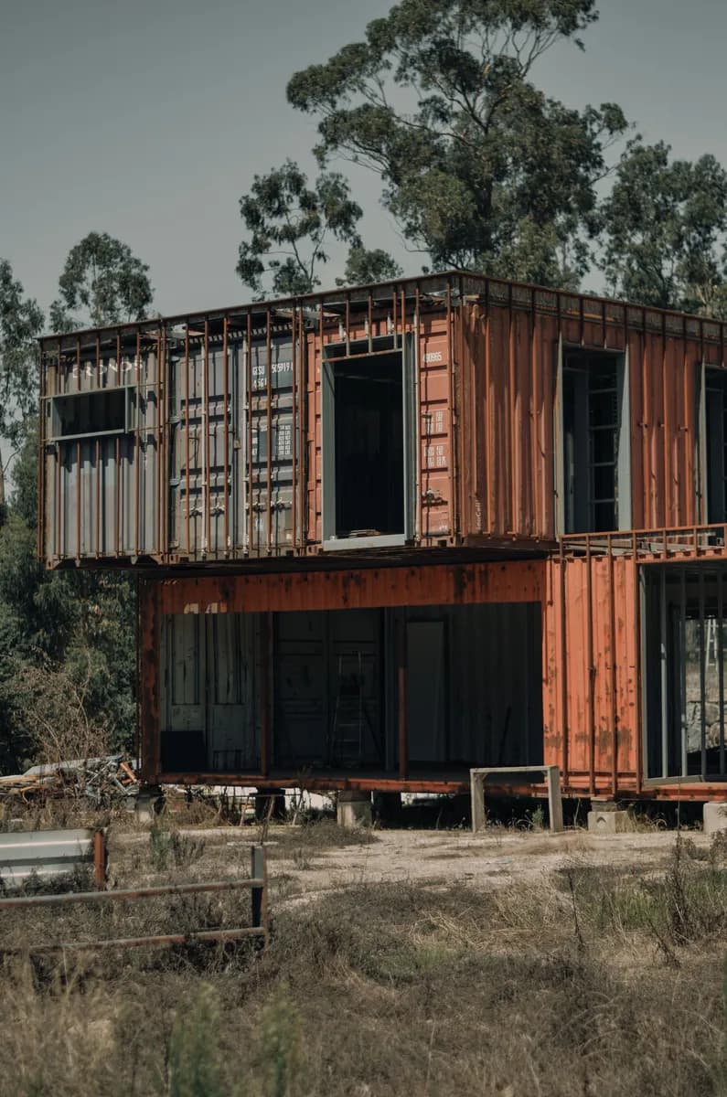 BookNoFees Beispielbild: Zweistöckiges Containerhaus mit grossen Fenstern zwischen Bäumen