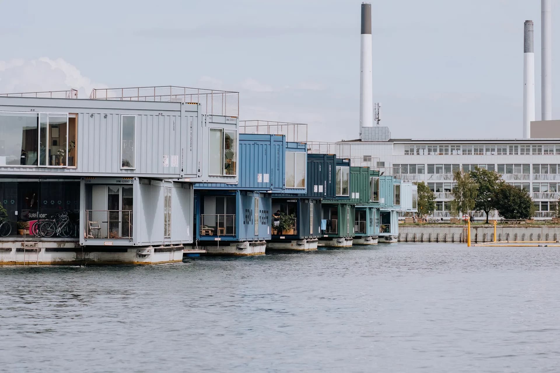 BookNoFees Beispielbild: Mehrstöckige Containerwohnbauten am Wasser mit grossen Fenstern