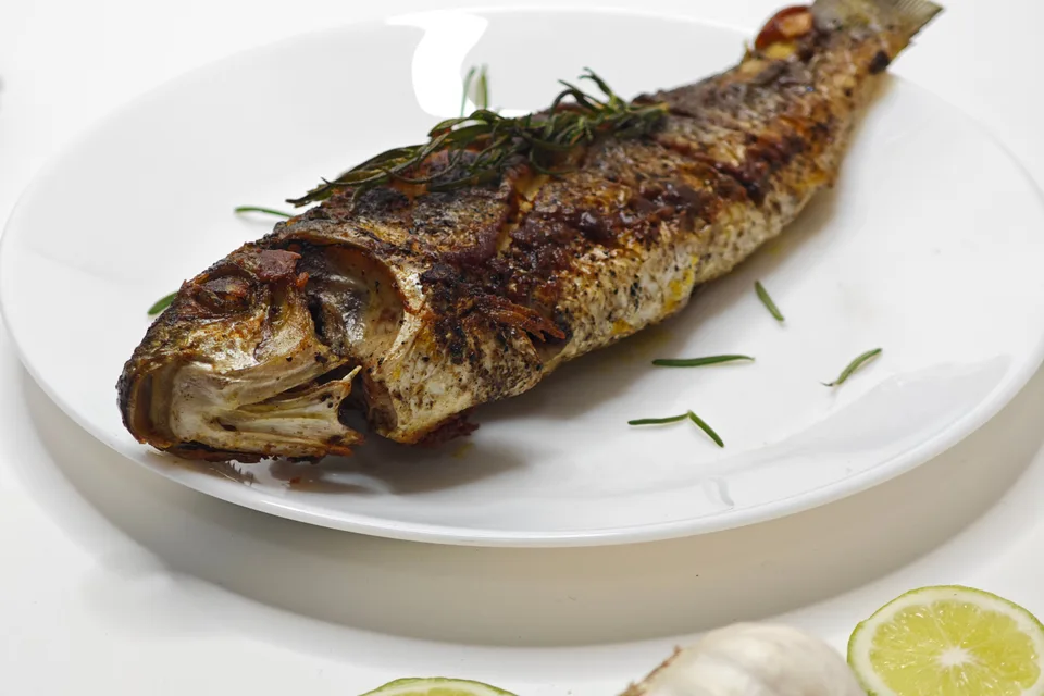 BookNoFees: Beispielfoto: Ganzer gegrillter Fisch auf einem weissen Teller