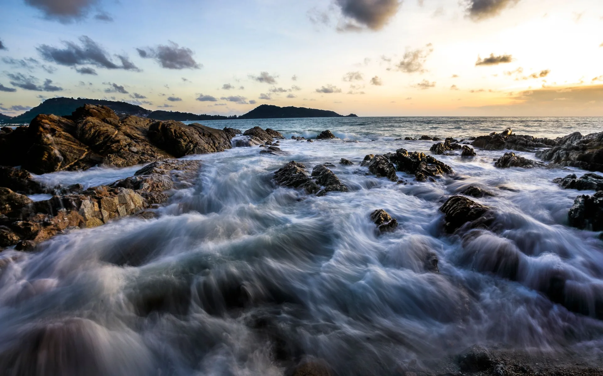 Wellen an der Felsenküste von Phuket bei Sonnenuntergang