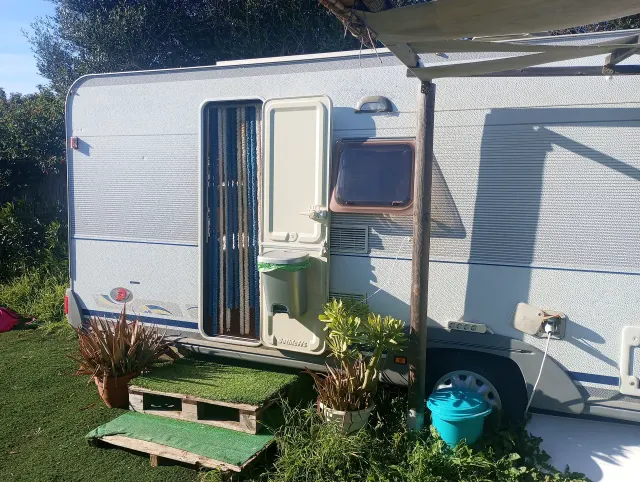 BookNoFees: Ferienwohnung in El Palmar De Vejer – Aussenansicht eines Oldtimer-Wohnwagens mit offener Tür, Markise und Topfpflanzen auf dem Rasen