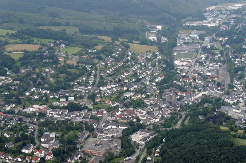 Die Stadt Sundern aus der Vogelperspektive: Häuser entlang des Röhr-Tals zwischen bewaldeten Hügeln