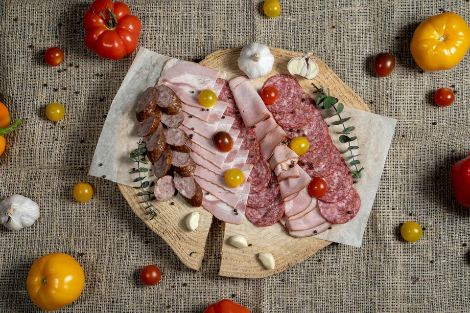 Beispielfoto: Aufgeschnittene Wurstwaren und Würste auf einem Holzbrett