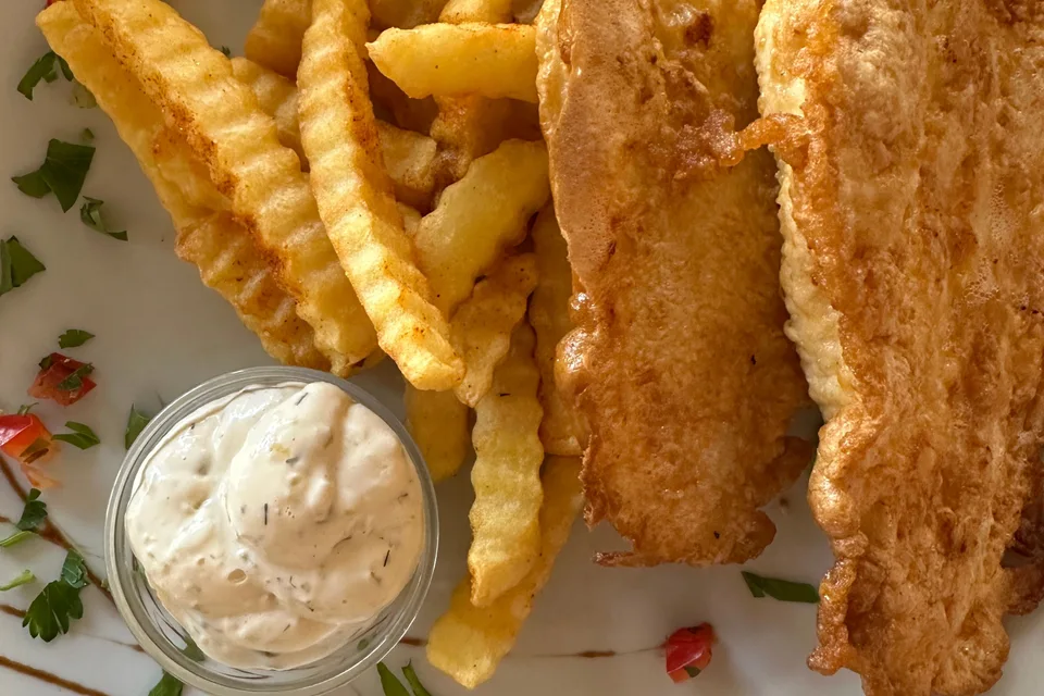 BookNoFees: Beispielfoto: Panierte Fischfilets mit wellenförmig geschnittenen Pommes frites und einer kleinen Schale Sosse