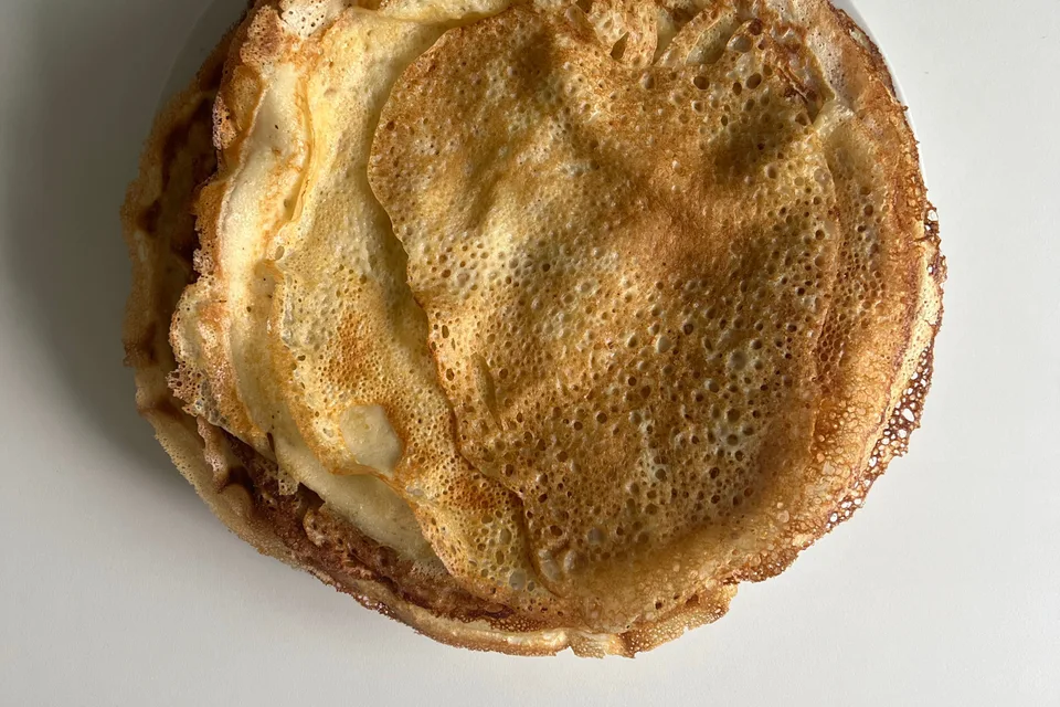 BookNoFees: Beispielfoto: Dünne, goldbraune Pfannkuchen auf einem weissen Teller